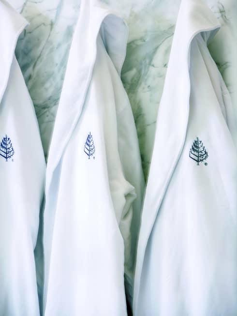 Close-up of white robes with embroidered Four Seasons Hotels logo