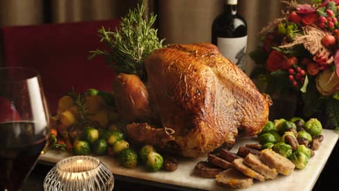 Roast turkey surrounded by vegetables on a board