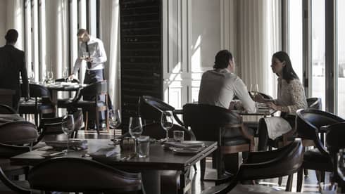 Couple dines by sunny window in modern La Capitale dining room