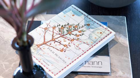Four Seasons hotel book with an illustrated cover featuring a flowering tree on a table