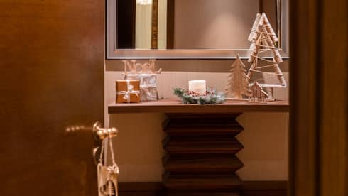 A shelf and a mirror with holiday decorations.