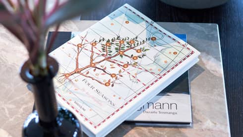 Four Seasons hotel book with an illustrated cover featuring a flowering tree on a table