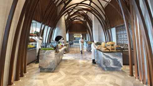 Soaring ceilings, wood arches over marble buffet tables where chefs prepare food