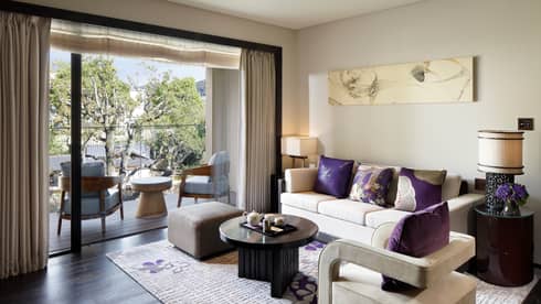 Living room sofa, armchair with plush purple pillows by open patio door, chairs