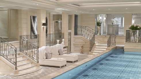 An indoor spa area with a pool and lounge chairs.
