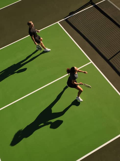 Aerial view of a man and woman playing pickleball on an outdoor court