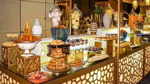 Buffet spread served on a large counter decorated in gold metal filigrees and cut-out patterns