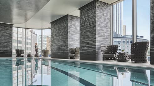 view of downtown boston skyline through the windows of the indoor pool