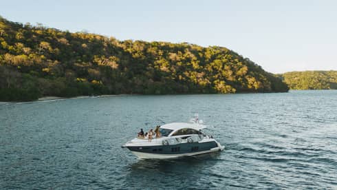 Power boat on water near green hills