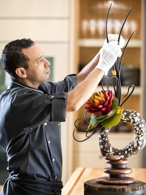 Portrait photo of Executive Pastry Chef Rabii Saber adjusting chocolate garnish