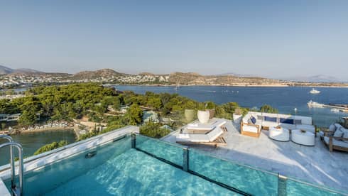Arion Riviera Suite Rooftop with plunge pool, lounge area below with white sofa and dining table, view of the Mediterranean Sea