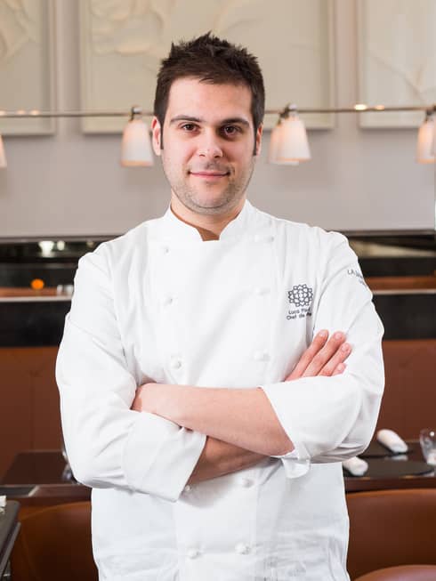 Portrait photo of La Dame de Pic Head Chef Luca Piscazzi wearing white chef's coat