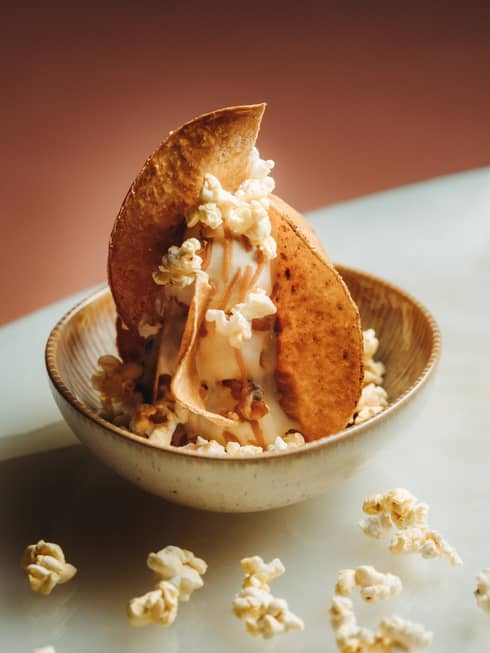 Dessert topped with slices of baked fruit and popcorn