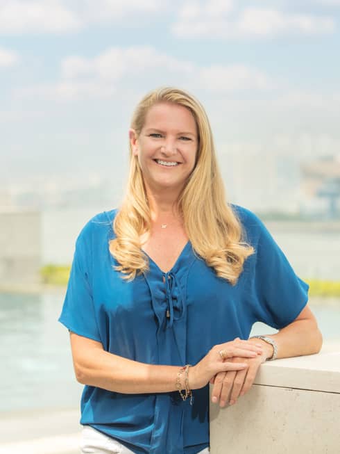 A smiling resident healer In?s De Beer poses by the outdoor pool