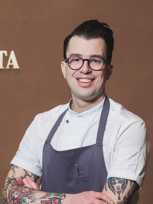 Chef Ethan Diamant smiling and wearing an apron and glasses