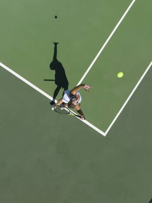Aerial view of a tennis player mid serve
