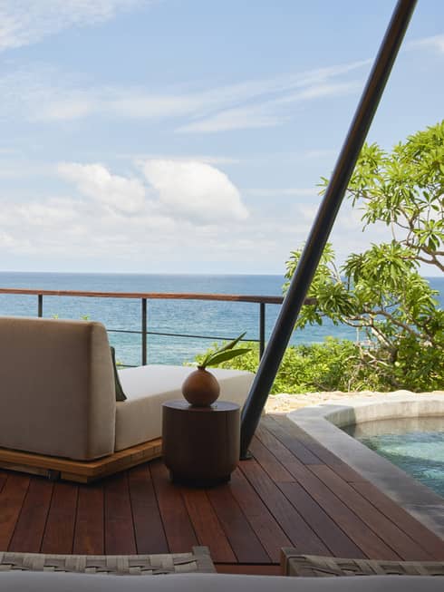 Shaded deck of luxury tent overlooking the ocean, with private plunge pool and two lounge chairs