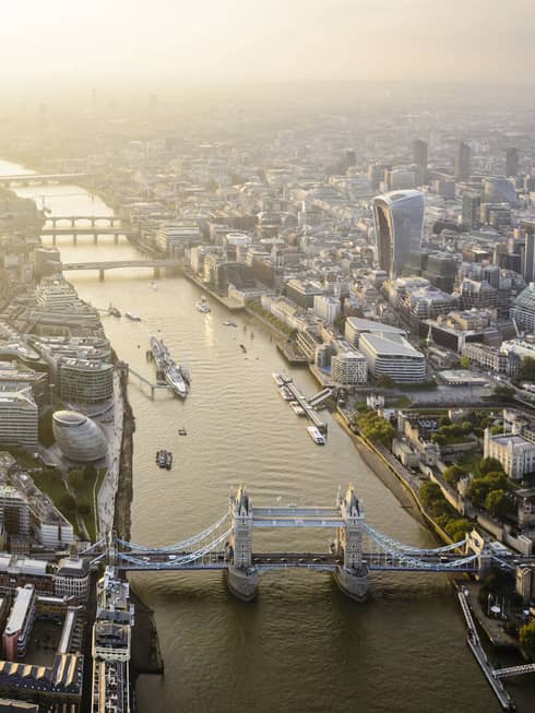 Aerial view of London city buildings along River Thames, London bridge in foreground