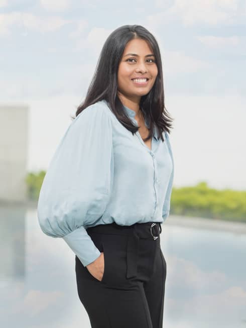 A smiling Resident healer Dr. Tania Bardhan standing at the pool