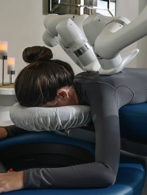 A guest laying on a massage table while getting a machined-powered massage