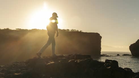 Man walks toward PuuPehee Rock in Lanai, Hawaii