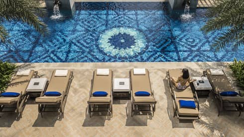 Aerial view of two patio lounge chairs and outdoor swimming pool deck