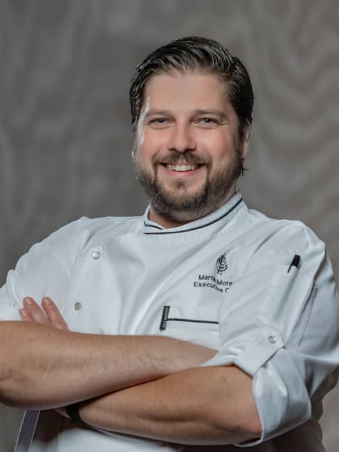 Chef Martin Morelli smiles and crosses him arms as he posed for a photo