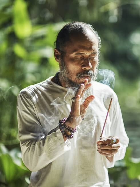 A healer holding a burning stick of incense  