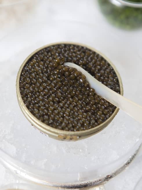 A container of fresh caviar served chilled over a bowl of ice