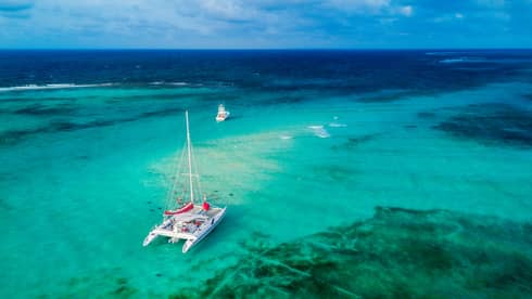Aerial view of a catamaran sailing turquoise-blue waters