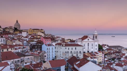 Aerial view of Lisbon traditional buildings with white houses, apartment buildings with brown roofs, white church