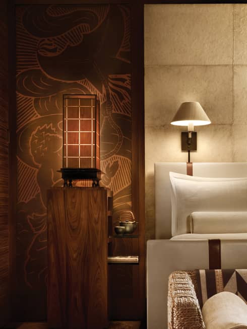 Handmade Nepalese Lokta wallpaper on tile panelled wall by lamp, hotel bed