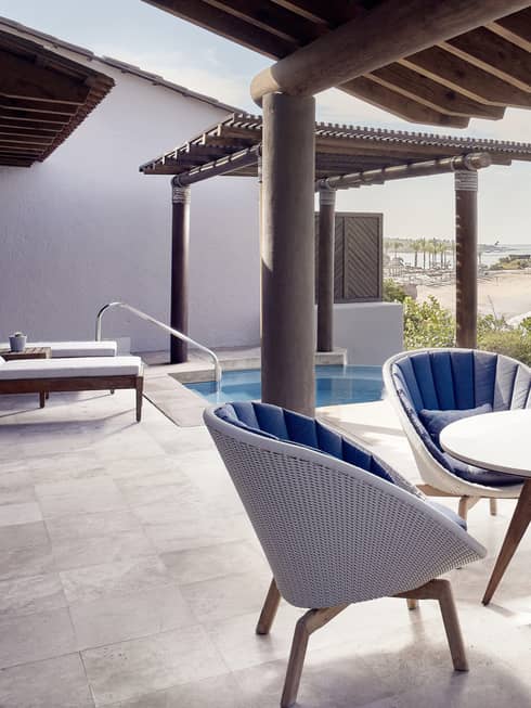 Outdoor terrace, dining table with four wicker chairs, plunge pool, ocean view