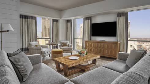 Luxury living room with grey sectional sofa, flat screen TV and city views