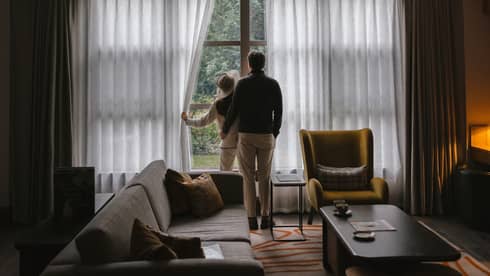 Man and woman looking out the window of their residence