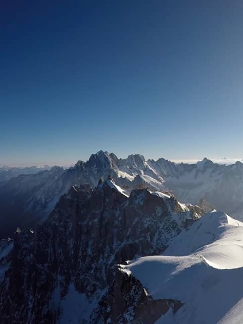 Snowy peaks of the French Alps with hazy sunshine in backdrop