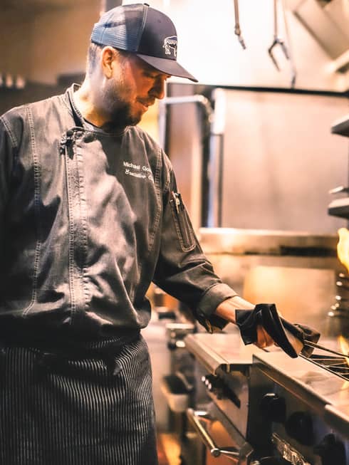 Chef Michael flambés food in a skillet