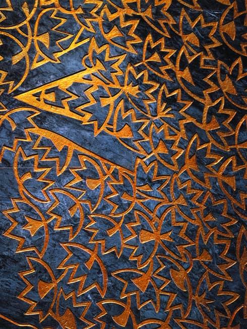 Close-up of orange leaf pattern facade over dark blue marble