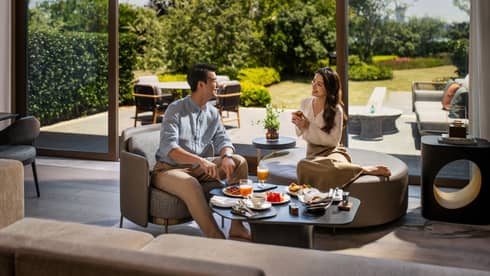 Man and woman enjoy In-Room Dining in luxury hotel villa at Four Seasons Hotel Suzhou, with private terrace