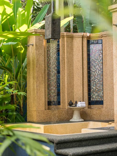 Tile and concrete fountain surrounded by tropical plants