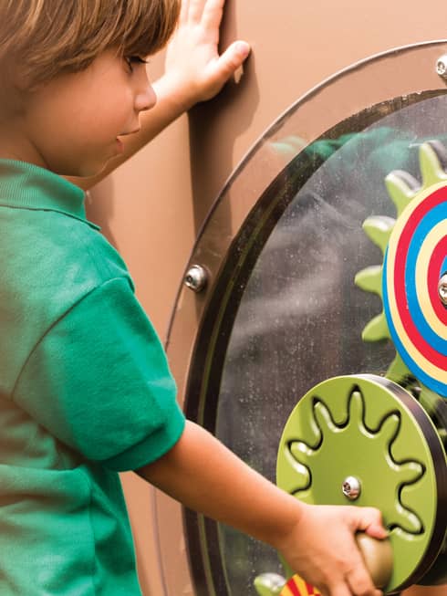 Young boy spins colourful wheel in Discovery Children's Museum
