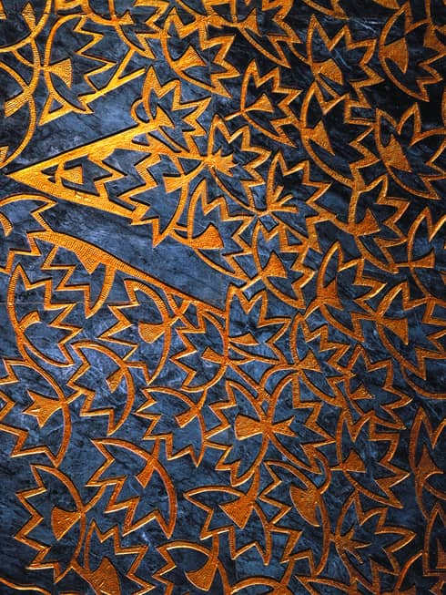 Close-up of orange leaf pattern facade over dark blue marble