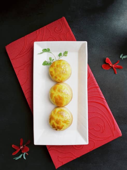 Three cornbread muffins on a white porcelain plate at Lung King Heen