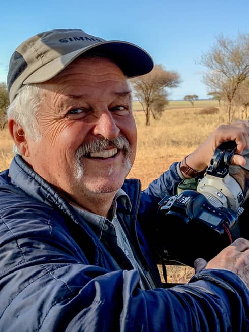 Portrait photo of resident wildlife photographer Rick Collins holding camera
