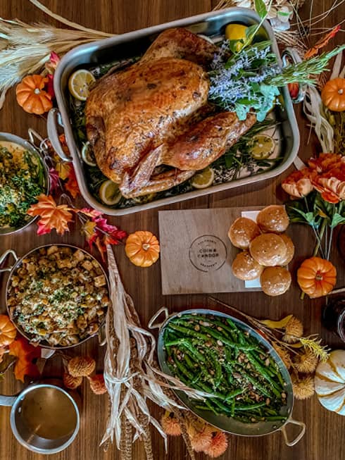 An assortment of thanksgiving food, including turkey, green beans, potato, and various other vegetables.