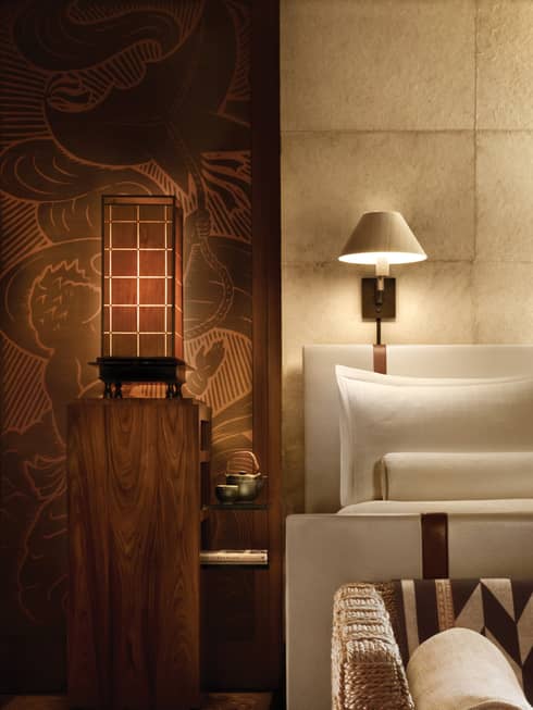 Handmade Nepalese Lokta wallpaper on tile panelled wall by lamp, hotel bed