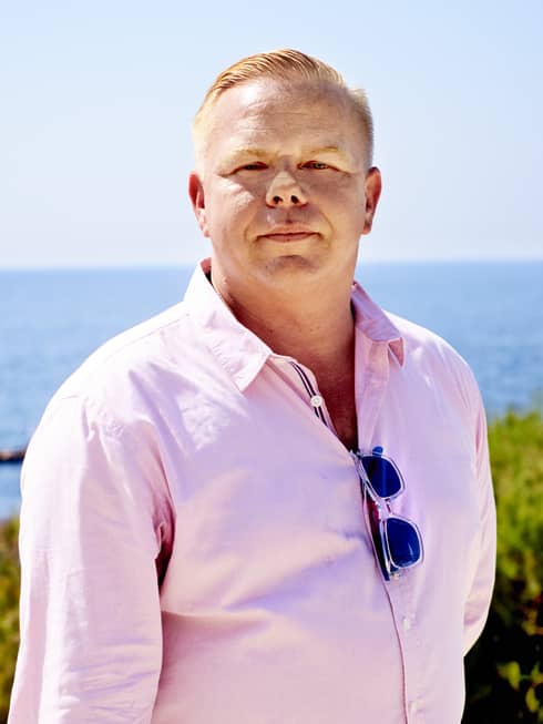 Portrait photo of Director of Club Dauphin Johann Burgo in front of sea