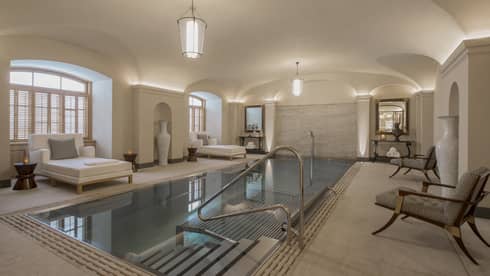 AVA Spa vitality pool  flanked by white lounge chairs under domed ceiling
