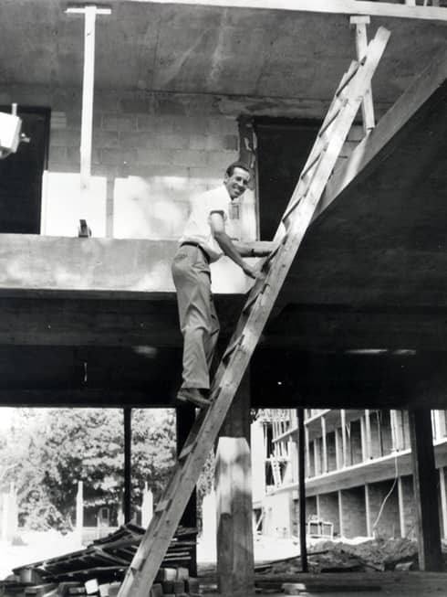 Black-and-white photo of Four Seasons chairman and founder Isadore Sharp on ladder