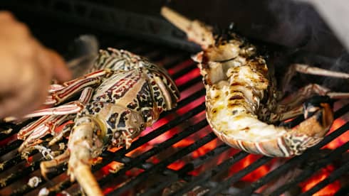 Seafood being cooked on a grill.